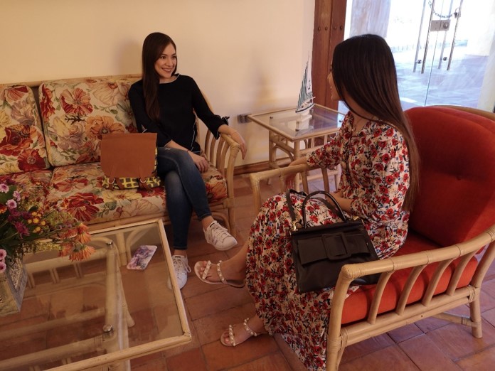 Dos mujeres conversando con bolsos Caroba & Bisento